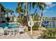 Backyard pool view with lounge chairs, palm trees, and a dock on the water at 3216 Purple Martin Dr # 121, Punta Gorda, FL 33950