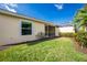 Lush backyard showcasing a vibrant lawn, manicured landscaping, and a glimpse of the screened lanai at 3748 Albacete Cir # 38, Punta Gorda, FL 33950