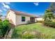 Backyard view featuring a well-maintained lawn, tasteful landscaping, and access to the screened lanai at 3748 Albacete Cir # 38, Punta Gorda, FL 33950