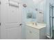 Cozy bathroom features a white vanity, decorative fish art, and a door with convenient towel hooks at 3748 Albacete Cir # 38, Punta Gorda, FL 33950