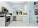 Well-equipped kitchen with stainless steel appliances and white cabinets, open to adjacent living areas at 3748 Albacete Cir # 38, Punta Gorda, FL 33950
