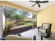 Inviting screened lanai featuring wicker furniture, a ceiling fan, and a serene view of the garden at 3748 Albacete Cir # 38, Punta Gorda, FL 33950