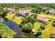 An aerial view of a waterfront property featuring mature landscaping and a screened-in lanai at 429 Dorchester St, Port Charlotte, FL 33954