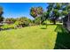 Spacious backyard with lush green grass, palm trees, and scenic pond at 429 Dorchester St, Port Charlotte, FL 33954