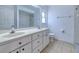 Bright bathroom with double sink vanity, large mirror and tiled flooring and shower at 429 Dorchester St, Port Charlotte, FL 33954