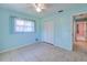 Bright blue bedroom features closet, tile flooring, window, and ceiling fan at 429 Dorchester St, Port Charlotte, FL 33954