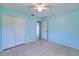 Bright blue bedroom featuring a closet, tile flooring, and ceiling fan at 429 Dorchester St, Port Charlotte, FL 33954