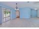 Open-concept living room with tile flooring, ceiling fan, and sliding doors, creating a bright and airy atmosphere at 429 Dorchester St, Port Charlotte, FL 33954