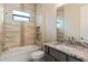 Bathroom featuring a tub with tiled walls, niche, granite countertops and stylish fixtures at 4320 Vasco St, Punta Gorda, FL 33950