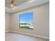 Bedroom with tray ceiling, ceiling fan, and large window overlooking waterfront at 4320 Vasco St, Punta Gorda, FL 33950