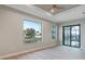 Bedroom with tray ceiling, ceiling fan, water view window, and sliding glass door at 4320 Vasco St, Punta Gorda, FL 33950