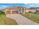 Beautifully landscaped home with a paver driveway, two-car garage, and manicured front yard at 4320 Vasco St, Punta Gorda, FL 33950