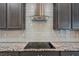 A modern kitchen with gray cabinets, granite countertops, stainless steel range hood, and a smooth cooktop at 4320 Vasco St, Punta Gorda, FL 33950