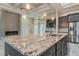 Granite counters, stainless steel appliances, wooden cabinets, and a stone fireplace enhance this kitchen at 4320 Vasco St, Punta Gorda, FL 33950