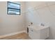 Laundry room featuring utility sink, wire rack, window, and wood-look tile flooring at 4320 Vasco St, Punta Gorda, FL 33950