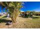 Quaint home featuring a screened patio and lush, tropical landscaping in the front yard at 5211 Beckham St, North Port, FL 34288