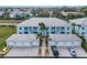 An aerial view of condos with neutral paint, private garages, and tidy landscaping at 5783 Sabal Trace Dr # 103B57, North Port, FL 34287