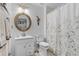 Bright, well-maintained bathroom with decorative mirror, shower with curtain and clean fixtures at 5783 Sabal Trace Dr # 103B57, North Port, FL 34287