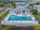 Aerial view of the community pool surrounded by lush greenery and lounge chairs at 5783 Sabal Trace Dr # 103B57, North Port, FL 34287