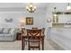 Charming dining area with a wooden table and chairs, illuminated by a modern chandelier at 5783 Sabal Trace Dr # 103B57, North Port, FL 34287
