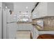 Bright kitchen with white cabinets, granite countertops, and modern appliances at 5783 Sabal Trace Dr # 103B57, North Port, FL 34287