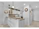 Well-lit kitchen featuring tile backsplash, granite counters, white cabinets, and a breakfast bar at 5783 Sabal Trace Dr # 103B57, North Port, FL 34287