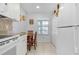 Cozy kitchen nook with a small table, seating, white appliances and tile flooring at 5783 Sabal Trace Dr # 103B57, North Port, FL 34287