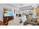 Bright living room with a flat-screen TV, cozy seating, and access to an outdoor patio at 5783 Sabal Trace Dr # 103B57, North Port, FL 34287