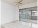 Spacious living room featuring tile floors, ceiling fan, and glass sliding doors to a sunroom at 6991 Pompey St, North Port, FL 34287