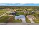 Aerial view of a new home featuring a metal roof, a long driveway, and a manicured lawn at 7363 N Moss Rose, Punta Gorda, FL 33955