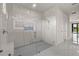 Modern bathroom showcasing a glass shower and white tile walls with natural light, and white fixtures at 7363 N Moss Rose, Punta Gorda, FL 33955