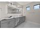 Elegant bathroom with dual sinks, gray cabinetry, quartz countertops, and a stylish mirror with accent lighting at 7363 N Moss Rose, Punta Gorda, FL 33955