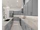 Modern kitchen with gray cabinetry, stainless steel appliances, and a large island with quartz countertops at 7363 N Moss Rose, Punta Gorda, FL 33955