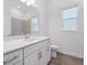 Bathroom featuring white vanity, light fixtures and two windows for natural light at 8604 Shore Lake Dr, Englewood, FL 34224