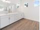 Bathroom with double sinks, quartz countertops, and wood-look tile floors at 8604 Shore Lake Dr, Englewood, FL 34224
