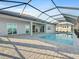 Rear exterior view featuring a screened pool and spacious patio at 8604 Shore Lake Dr, Englewood, FL 34224