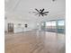 Spacious living room features modern ceiling fan, tile floors, and access to screened lanai at 8604 Shore Lake Dr, Englewood, FL 34224