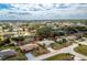 Single-story home surrounded by mature trees and landscaped with tropical shrubs at 917 Tropical Nw Ave, Port Charlotte, FL 33948