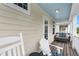 Relaxing back porch featuring comfortable seating and rocking chairs on a wooden deck at 12492 Shimmering Oak Cir, Venice, FL 34293