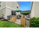 Backyard features a paved patio with outdoor dining set, dark rocking chairs and a green umbrella at 12492 Shimmering Oak Cir, Venice, FL 34293