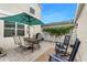 Backyard featuring a paved patio with dining area, rocking chairs, and a lush green vine wall at 12492 Shimmering Oak Cir, Venice, FL 34293