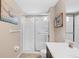 Bathroom with tiled floor, glass shower stall, white vanity, and coastal-themed decorations at 12492 Shimmering Oak Cir, Venice, FL 34293