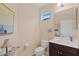 Cozy half-bathroom featuring a dark wood vanity, and a framed window for natural lighting at 12492 Shimmering Oak Cir, Venice, FL 34293