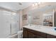 Bathroom featuring tiled shower with glass door and a large mirror over the sink at 12492 Shimmering Oak Cir, Venice, FL 34293