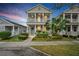 Charming two-story home features a welcoming porch, blue door, and beautifully landscaped front yard at 12492 Shimmering Oak Cir, Venice, FL 34293