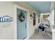 Inviting front porch with coastal decor, seating, and a charming beach-themed wreath on a blue front door at 12492 Shimmering Oak Cir, Venice, FL 34293