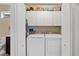 Convenient laundry room with washer, dryer, cabinets for storage, and a toilet at 12492 Shimmering Oak Cir, Venice, FL 34293