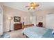 Spacious bedroom with a ceiling fan, a dresser with mirror, and comfortable furniture at 12492 Shimmering Oak Cir, Venice, FL 34293