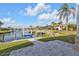 Waterfront backyard featuring a well-maintained lawn, canal access, and a paver patio leading to the dock at 1303 Casey Key Dr, Punta Gorda, FL 33950