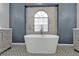 Elegant bathroom featuring a modern tub with a large window, gray cabinets and decorative floor tiles at 1303 Casey Key Dr, Punta Gorda, FL 33950